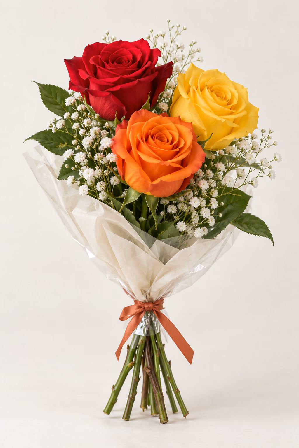 Sunset Rose 3-Rose Bouquet: One red, one orange and one yellow rose, white baby's breath and greenery. Traditionally hand-tied in simple tissue and clear wrapping with a coordinating ribbon.